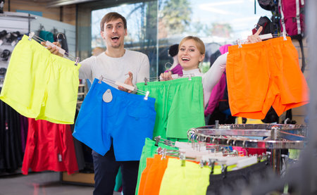Husband and wife choose summer shorts together in clothing storeの写真素材