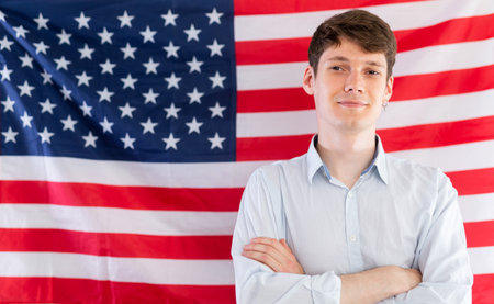 Young guy posing in front of USA flagの写真素材