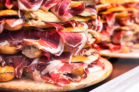 Spanish bocadillos with Iberian ham, presented in a slide on displayの写真素材