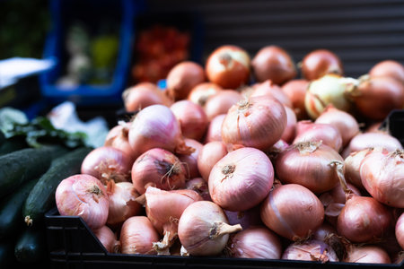 Box is filled with onions, grocery store display case.の写真素材