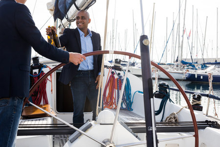 two male business partners celebrating on a yacht in the seaportの写真素材