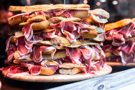 mouth watering sandwiches with jamon laid out in a slide on shop window