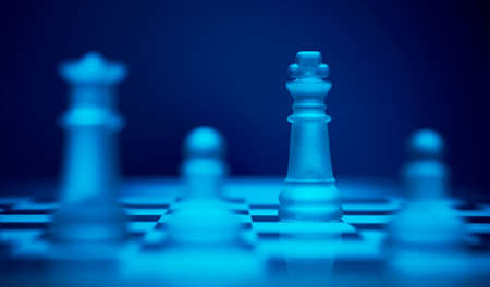 Chess game. King defended by his pawns and queen on the chess board.の写真素材