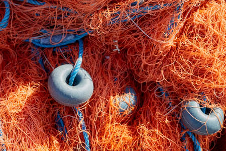 Fishing net with blue rope and buoys on the dock. Close up.の写真素材