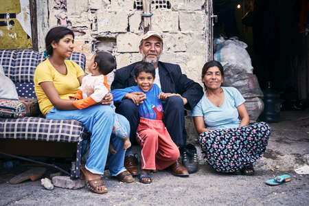 KAGITHANE GULTEPE, ISTANBUL, TURKEY - AUG. 2008: Group portrait of a poor Turkish (roman) gypsy family sitting on the street in front of their ruin shanty house. Editorial use only.のeditorial素材