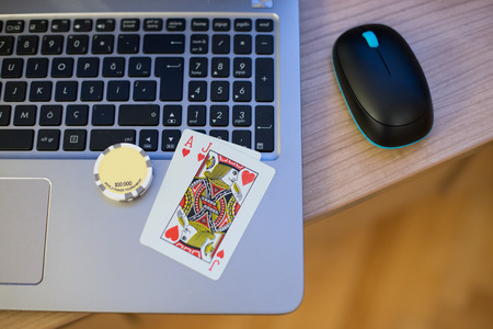 Playing cards and poker chips on the notebookの写真素材