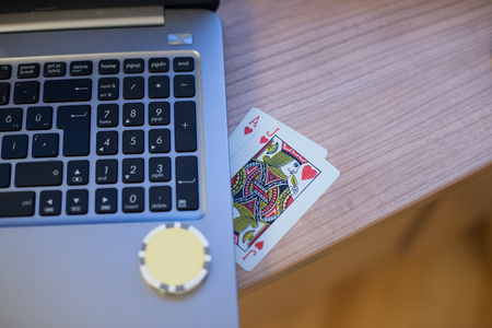 Playing cards and poker chips on the notebookの写真素材