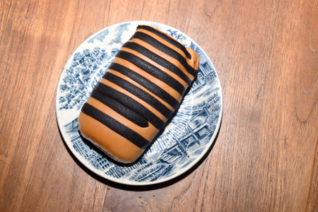 Chocolate striped brad on a saucer on a wooden backgroundの写真素材