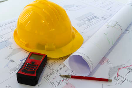 An office desk with the project papers and protective helmet