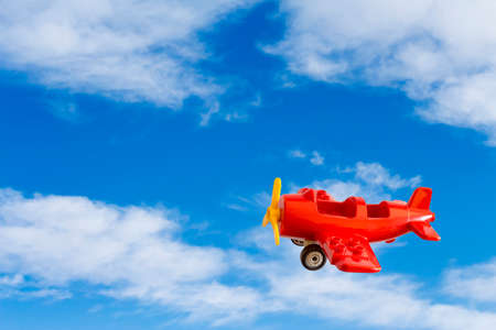 Abstract: red toy airplane on a background of blue skyの写真素材