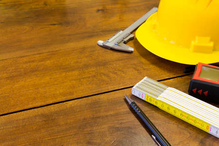Safety helmet and tools to architect on wooden background
