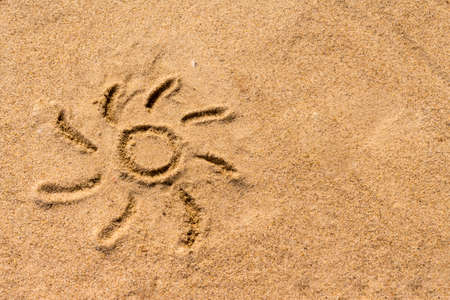 Sun drawn on the sand of the seaの写真素材