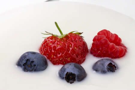 close-up of white yogurt with blueberries, strawberries and raspberriesの写真素材