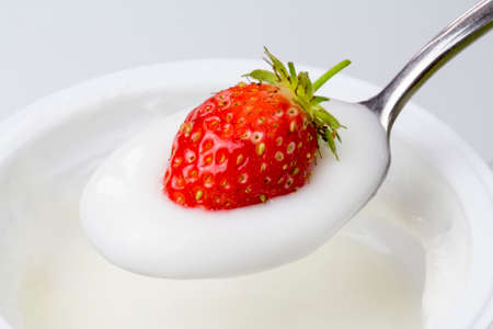 close-up of spoon of yogurt with strawberriesの写真素材