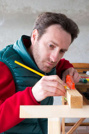 Young Carpenter at work building a wooden frameの写真素材