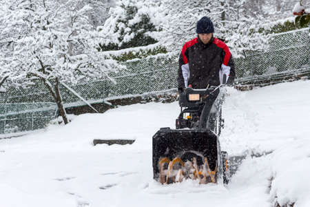 man removing snow with a snow blowerの写真素材