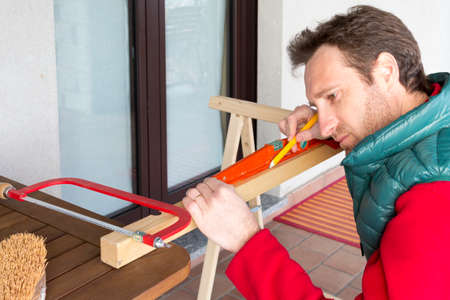 Young Carpenter at work building a wooden frameの写真素材