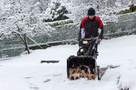 man removing snow with a snow blowerの写真素材