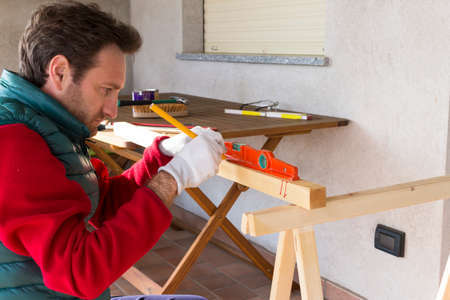 Young Carpenter at work building a wooden frameの写真素材