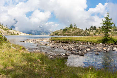 Alpine landscape with lake, mountains and fir treesの写真素材