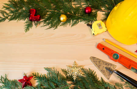 Protective helmet, mason tools  and Christmas decorations on wooden backgroundの写真素材
