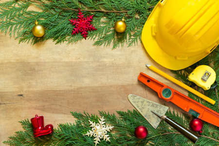 Protective helmet, mason tools  and Christmas decorations on wooden backgroundの写真素材