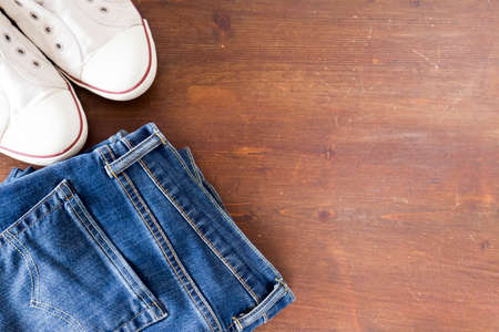 Close up of jeans  pants and sneakers on wooden backgroundの写真素材