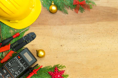 Electrician tools and instruments  and Christmas decorations on wooden backgroundの写真素材