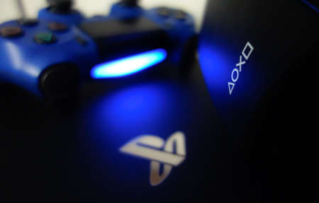 Sony Playstation logo illuminated on blue light from game controllerのeditorial素材