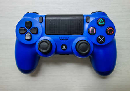 Sony Playstation blue game controller in a gray textured background