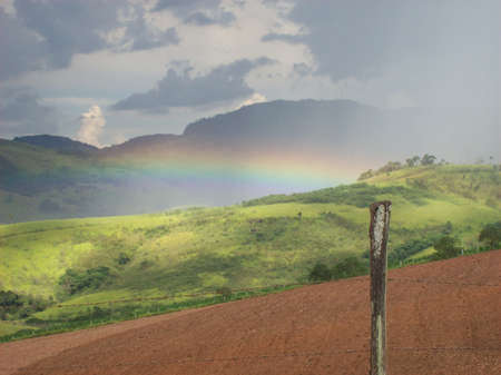 rainbow over countryside landscape at a summer day.の写真素材