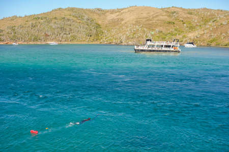 Snorkeler swims on the surface of the ocean with the help of a buoyの写真素材