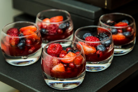 Food Photography for breackfast, luch and dinner,  shots is selective focus with shallow depth of field. Healthy fruit salad with fresh berries in glasses on a black backgroundの写真素材