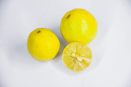 Yellow organic raw lemon, studio closeup photo, isolated on white background, natural juicy...