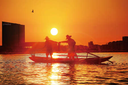 Silhouette of fishermen on the boat during sunsetのeditorial素材