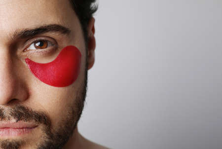 Close-up portrait of bearded man with hydrating patches under eyes. Isolated.の写真素材