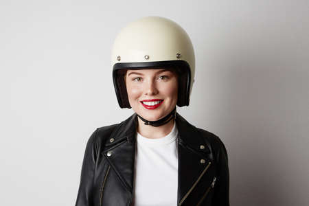 Young biker woman posing o the white background. Isolated.の写真素材