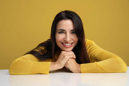 Young woman smiling and posing on the yellow background.の写真素材