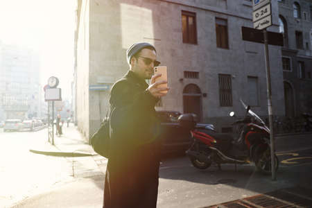 Young hipster walking in the street and taking photos.の写真素材