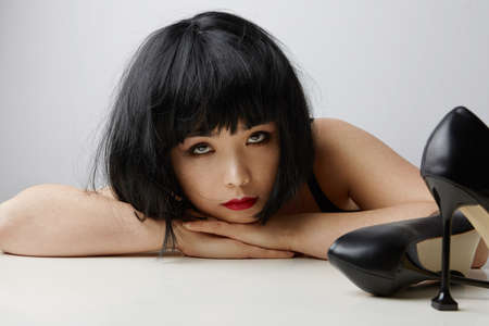 Front view of young Chinese woman with short hair posing on the white background. Isolated.