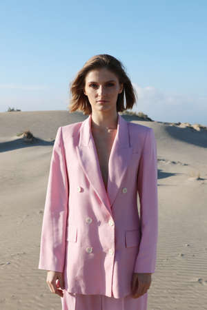 Vertical portrait of young woman enjoying sunny weather on the beach. Fashion and outdoor.の写真素材