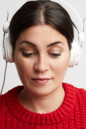 Portrait of young woman listening the music in her headphone. Vertical.