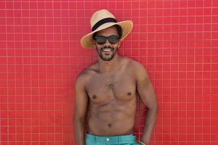 Black handsome guy enjoying a summer day on the beach with white ball. Horizontal.