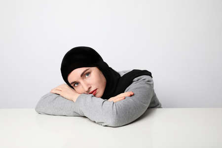 Muslim young woman wearing hijab posing on the white wall.の写真素材