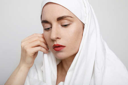 Side portrait of a beautiful young Muslim woman wearing a hijab on her head.