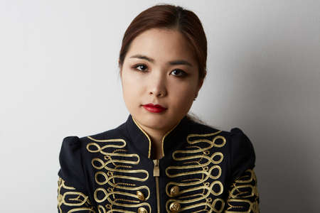 Young beautiful Chinese woman standing over isolated white background. Positive person. Space for your text.の写真素材