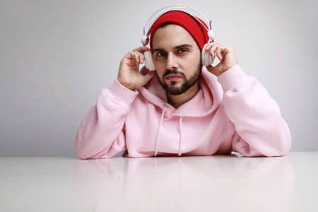 Head shot of young bearded dj man wearing headphones wearing funky cloths over white background.の写真素材