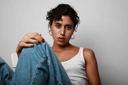 Young confident teenage girl posing over white background. Teenage issues and confidence problem.
