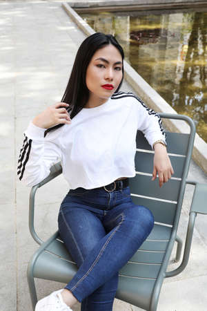Headshot of attractive sporty asian woman with perfect soft colorful makeup. Fashion shot outdoors