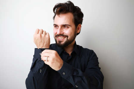 Portrait of young businessman smiling and wearing navy blue shirt. Posing over white background.